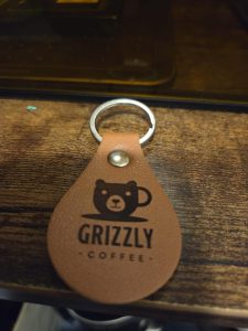 Custom leather teardrop keychain with engraved bear coffee cup logo – Grizzly Coffee design
